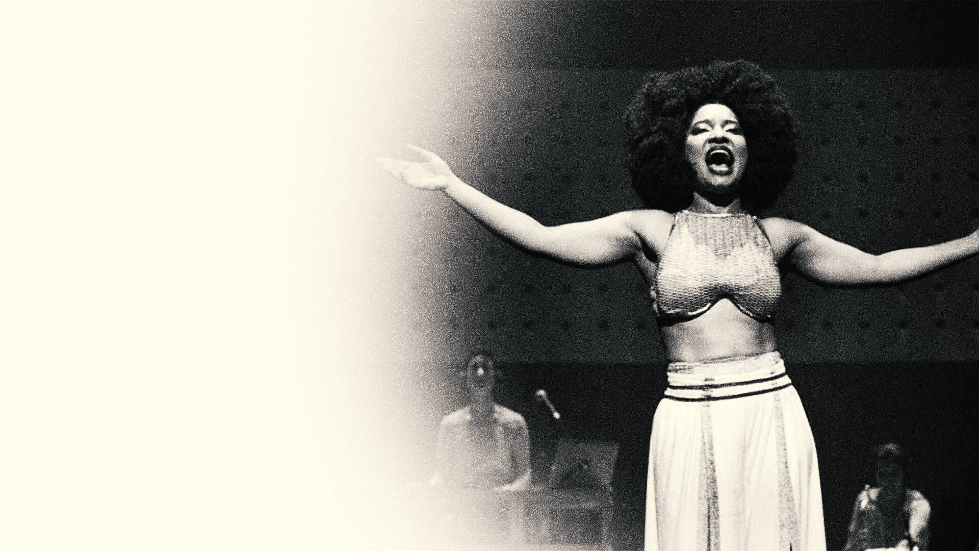 Elza Soares canta de braços abertos no palco, em foto de arquivo em preto e branco