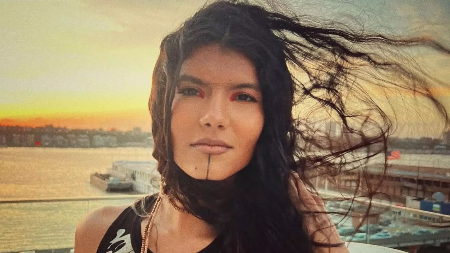 Retrato de Zaya Guarani com o cabelo ao vento, à beira do rio