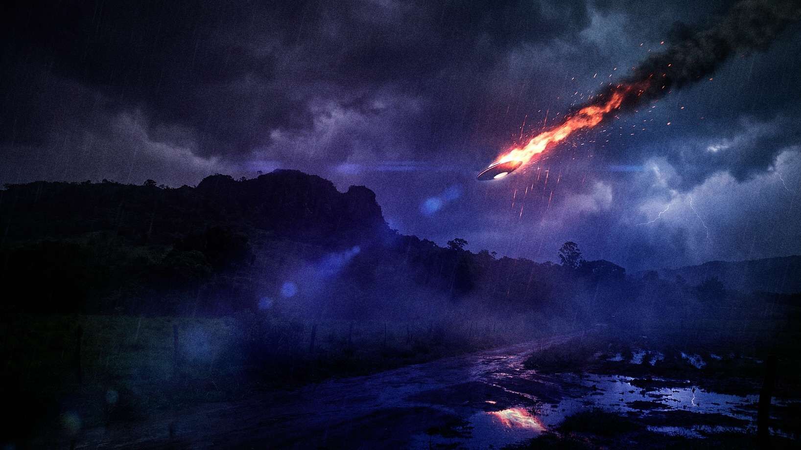 Objeto em chamas cruza um céu de tempestade sobre as montanhas